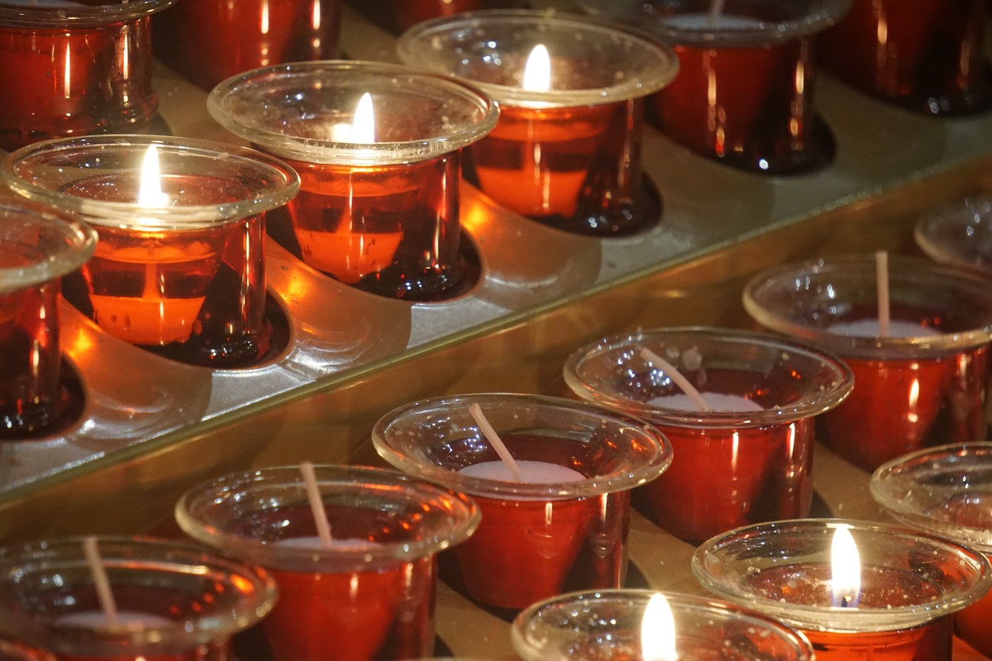 Rows of red votive candles in the church, several of them lit